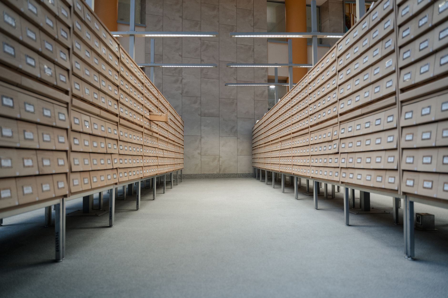 Pasillo de un archivo institucional con estanterías de expedientes a ambos lados